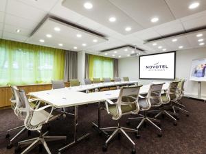 a conference room with a long table and chairs at Novotel Limoges Le Lac in Limoges +80 photos