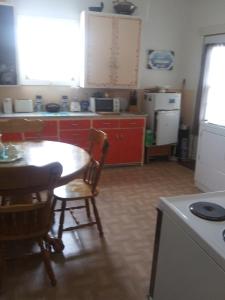 a kitchen with a table and a kitchen with a refrigerator at Appartement centre ville de Campbellton NB in Campbellton