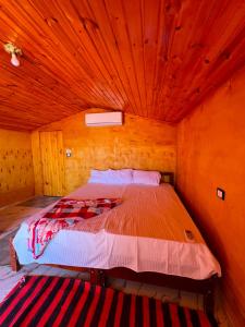 a bed in a room with a wooden ceiling at Marhaba Camp in Nuweiba