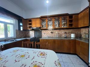 a kitchen with wooden cabinets and a counter top at Villa Victoria in Gjirokastër