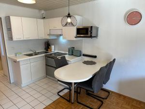 a kitchen with a table and chairs and a clock at Ferienwohnung mit Terrasse - Hunde willkommen in Falkenstein