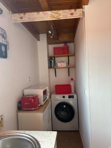 a laundry room with a washing machine and a washer at La casina de Marga in Villaviciosa