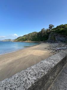 a beach with a retaining wall next to the water at La casina de Marga in Villaviciosa +3 photos