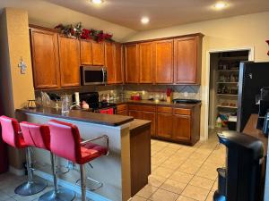 a kitchen with wooden cabinets and pink bar stools at Trunks up! Spacious home ready for a fun time! in Lancaster