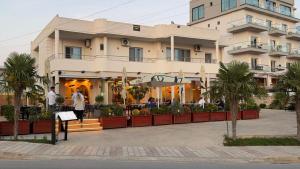 a building with people walking in front of it at Prestige Home KSAMIL in Ksamil