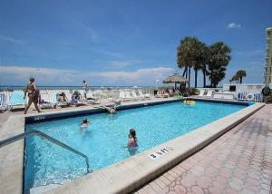 a swimming pool at a resort with people in it at Sea Breeze 101 Beach Bliss in St. Pete Beach