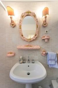 a bathroom with a sink and a mirror on the wall at House H-ELIOS in Lovran
