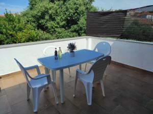 a blue table and chairs on a patio at Apartments Vera in Ližnjan +21 photos