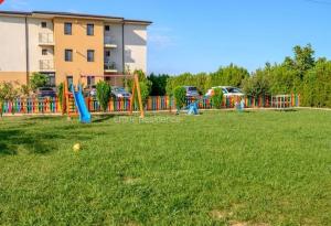 a playground in a grassy field with a building at AKT Residence in Agigea