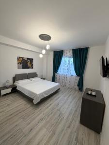 a bedroom with a large white bed and a table at AKT Residence in Agigea