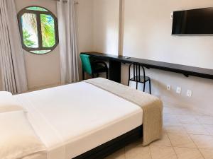 a bedroom with a bed and a desk and a television at Hotel Econotel by Bsb Inn in Brasília