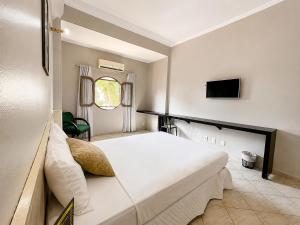 a bedroom with a large white bed and a tv at Hotel Econotel by Bsb Inn in Brasília