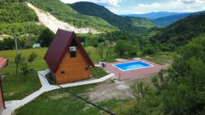 ein kleines Haus mit Swimmingpool neben einem Berg in der Unterkunft Villa Viktor Šipovo in Šipovo