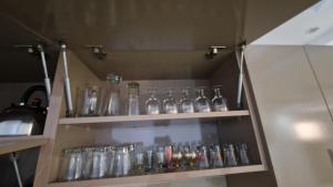 a bunch of glass bottles on shelves in a kitchen at Hostel the little prince in Tarfaya