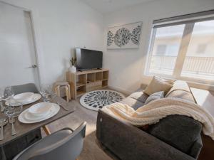 a living room with a couch and a table at Vancouver Mandy Laneway Home in Vancouver