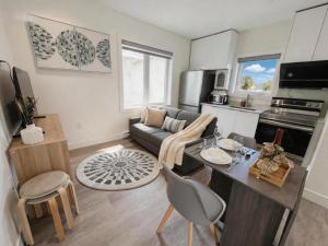 a kitchen and living room with a couch and a table at Vancouver Mandy Laneway Home in Vancouver