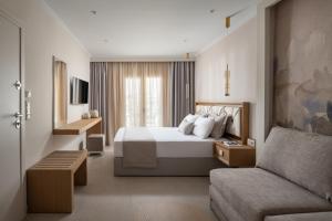 a hotel room with a bed and a couch at AMARÉ suites in Nikiti