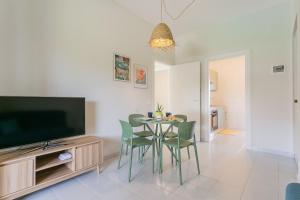 a living room with a table and chairs and a television at Maréa - Boutique Stay in Torre a Mare