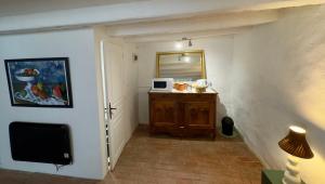 a hallway with a room with a microwave and a mirror at La Maison de Lyon in Saint-Laurent-de-Céris