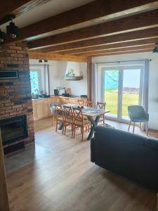 a living room with a fireplace and a table and chairs at Chata w Bieszczadach ,,Słońce i Cień" PIĘKNE WIDOKI in Baligród