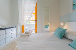 a bedroom with a large white bed with blue pillows at Maréa - Boutique Stay in Torre a Mare +23 photos