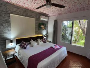 a bedroom with a large bed with a pink ceiling at Maria's Kan Kin in Isla Mujeres