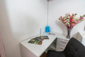 a white desk with a vase of flowers on it at Casa Lady in Pontremoli
