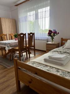 a bedroom with a table and chairs and a bed at Wakacje u Dziadków in Ruciane-Nida