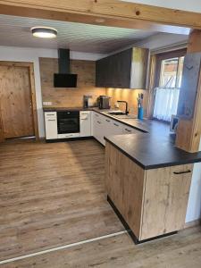 a kitchen with white cabinets and a black counter top at Ferienwohnung Langwallner in Grossarl +30 photos