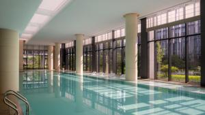an empty pool in a building with windows at Kimpton Nine Trees Shanghai by IHG in Shanghai