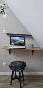 a laptop computer sitting on a desk under a staircase at Le Cosy Houdan in Goussainville