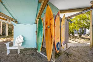 a bunch of surfboards are lined up against a wall at 8951 - Ozzie's Island Hideaway in Hatteras