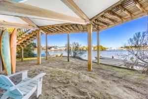 a porch with a bench and a surfboard on the beach at 8951 - Ozzie's Island Hideaway in Hatteras +39 photos