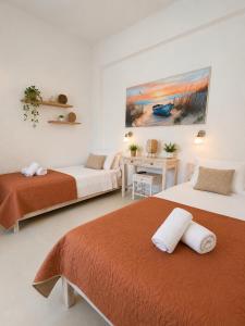 a bedroom with two beds and a desk and a table at Εmmi in Koutsounari