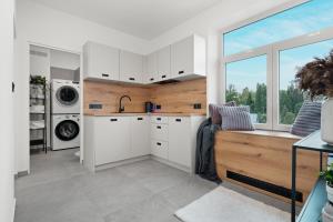 a kitchen with white cabinets and a window at SPECTRA Rooms in Velké Meziříčí