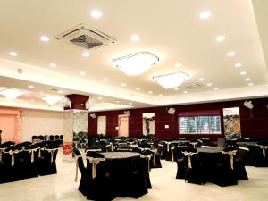 a banquet hall with black tables and chairs at Aadhya Hotel & Adhira Restaurant in Orchha