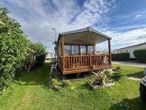 a gazebo sitting in the grass in a yard at Flower Bay - Beach Drive 009 in Prestatyn