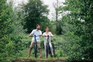 a man and a woman are riding bikes at La Bulle au bord de l'eau in Épagne-Épagnette +2 photos