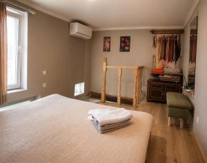 a bedroom with a bed and a chair and a window at Welcome Guests in Tbilisi City