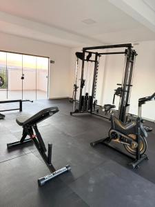a gym with several treadmills and machines in a room at Studio Moderno com Internet e Garagem. in Três Corações