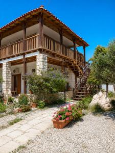 a large house with a wooden balcony and flowers at Εmmi in Koutsounari