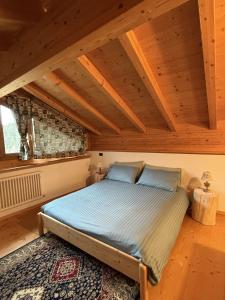a bed in a room with a wooden ceiling at Villetta Ximenes in Panchià
