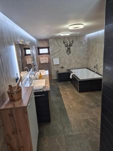 a large bathroom with a tub and a sink at MY TIME BLED Holiday House with sauna in Zgornje Gorje