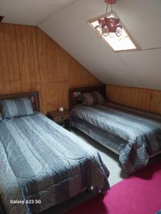 a bedroom with two beds and a skylight at Casa Halcon de Lagunitas in Puerto Montt