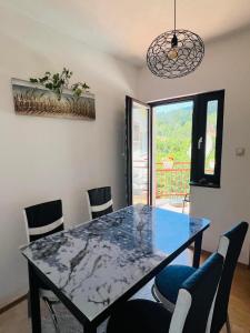a dining room with a table and chairs and a window at Stan na dan Grahovo in Bosansko Grahovo +6 photos
