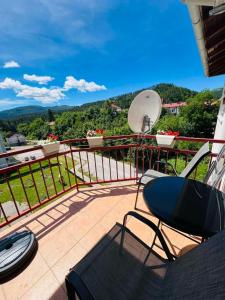 a balcony with a table and a chair on a balcony at Stan na dan Grahovo in Bosansko Grahovo