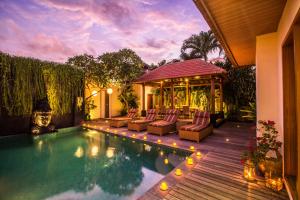 a backyard with a swimming pool and a gazebo at Villa Seriska Dua Sanur with Private Pool in Sanur