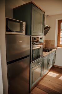 a kitchen with a stainless steel refrigerator and microwave at Le loft de Marthe in Bonnières