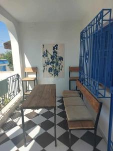 a room with a table and chairs on a balcony at SecretVilla in Ghār al Milḩ