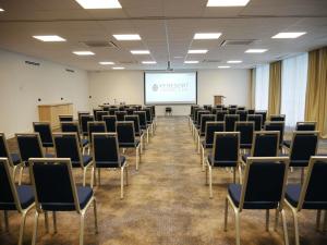 a room filled with chairs and a projector screen at Mercure Vichy in Vichy